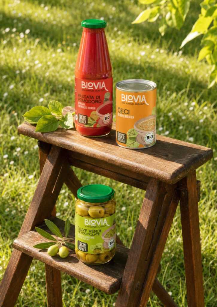 BIOVIA organic tomato passata, chickpeas and pitted green olives on a wooden stepladder outdoors