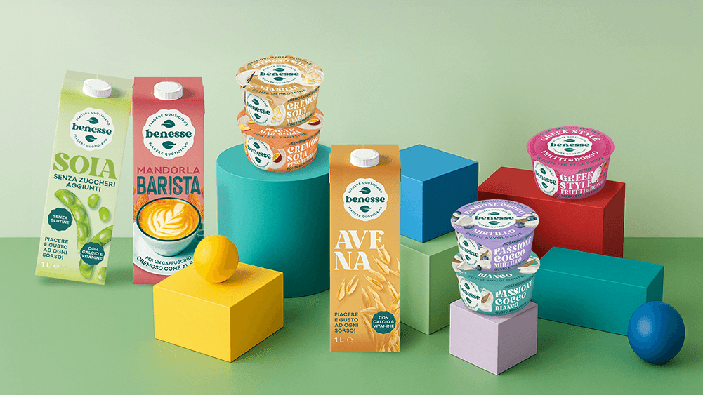 Immagine linea Benesse su fondo colorato con Bevanda di soia senza zuccheri aggiunti, bevanda mandorla barista, bevanda vegetale all'avena, yogurt vegetali passion cocco, e yogurt greek style vegetale.