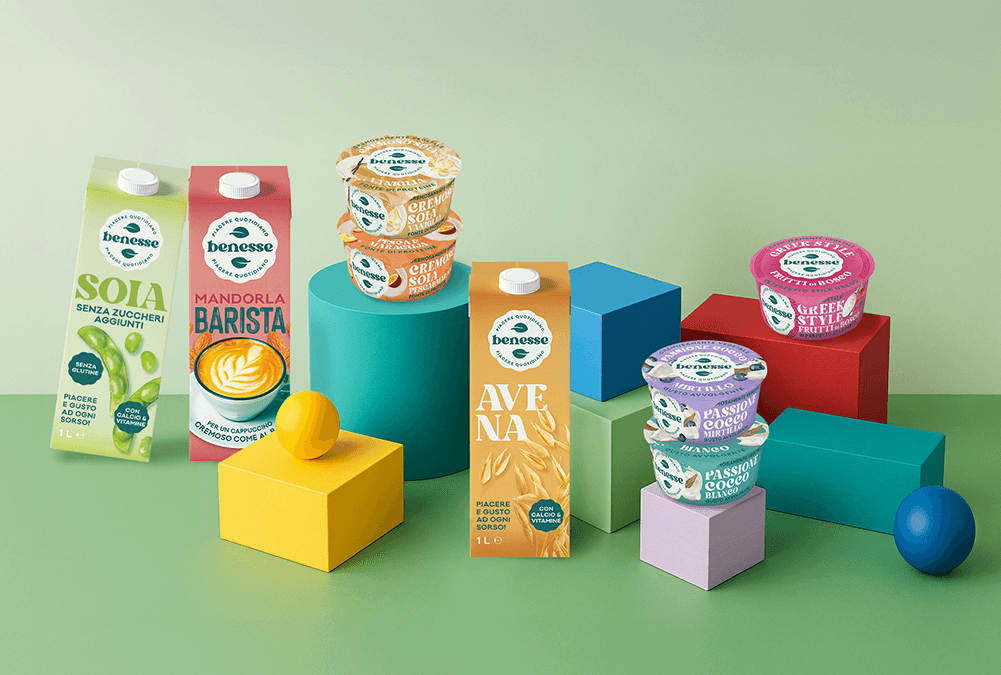 Immagine linea Benesse su fondo colorato con Bevanda di soia senza zuccheri aggiunti, bevanda mandorla barista, bevanda vegetale all'avena, yogurt vegetali passion cocco, e yogurt greek style vegetale.