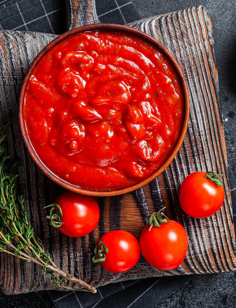 Passata di pomodoro: ciotola di passata rossa con pomodori, aglio e olio extravergine
