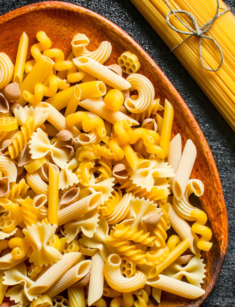 Pasta secca assortita in vari formati come penne, farfalle e fusilli