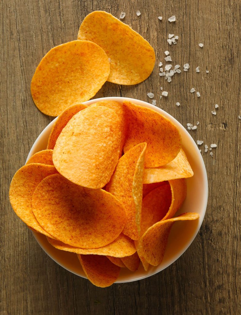 Ciotola di patatine croccanti sottili con granelli di sale, snack salato classico ideale per aperitivi e momenti di pausa.