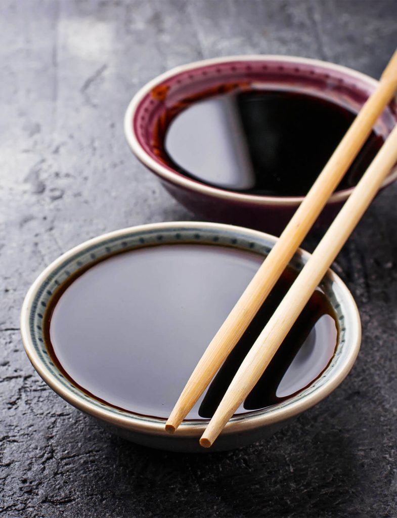 Ciotole con salsa di soia e bacchette, condimento iconico della cucina asiatica.