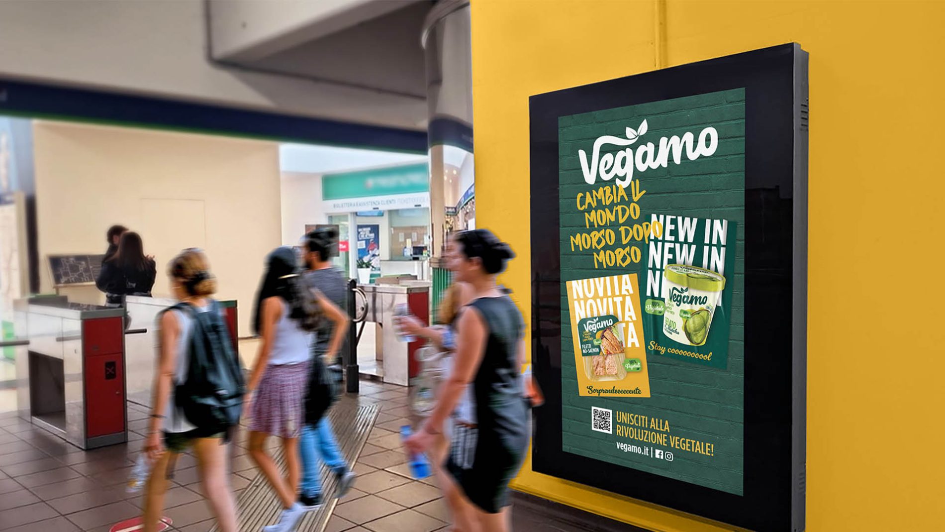 Affissione della campagna Vegamo in una stazione di Milano, con passeggeri di passaggio