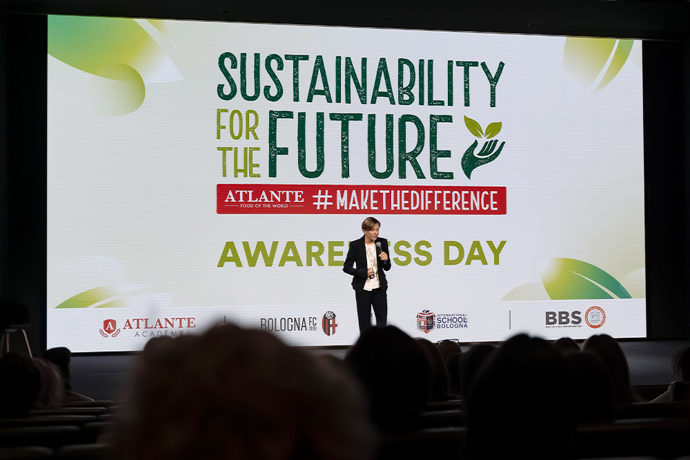 Relatrice sul palco con schermo alle spalle